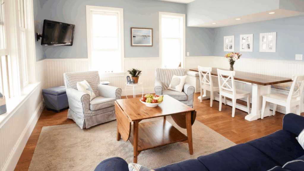 Salon i jadalnia w stylu hampton z błękitnymi ścianami i białymi meblami