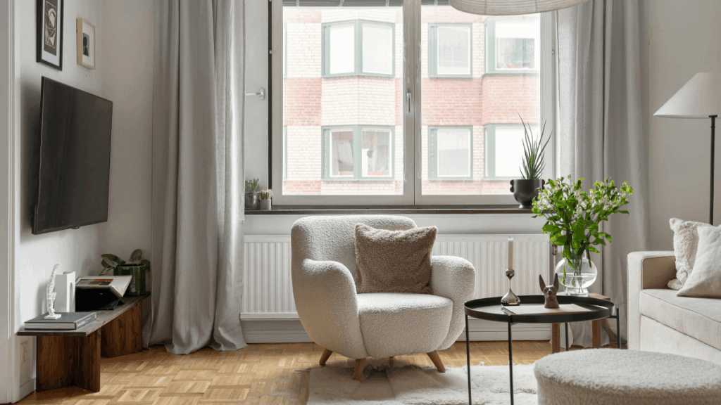 Przytulny salon z dużym oknem i zasłonami pokazujący skuteczne wyciszenie pokoju