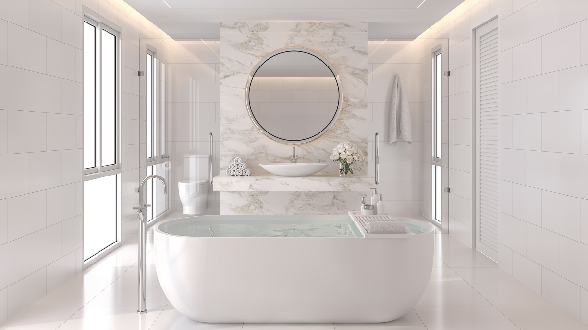 Biała łazienka z wolnostojącą wanną, marmurową ścianą i okrągłym lustrem