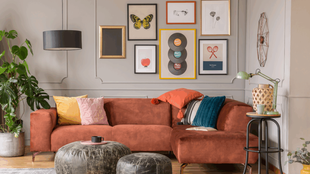 Styl eklektyczny w salonie z kolorową sofą, galerią obrazów i roślinami