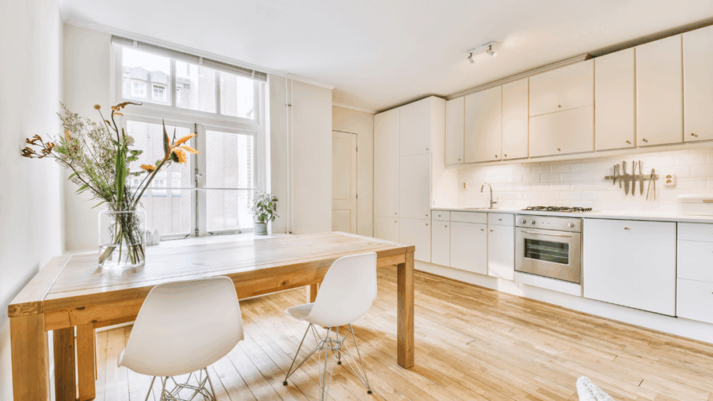 Wykończenie salonu z aneksem kuchennym w jasnych kolorach i drewnie