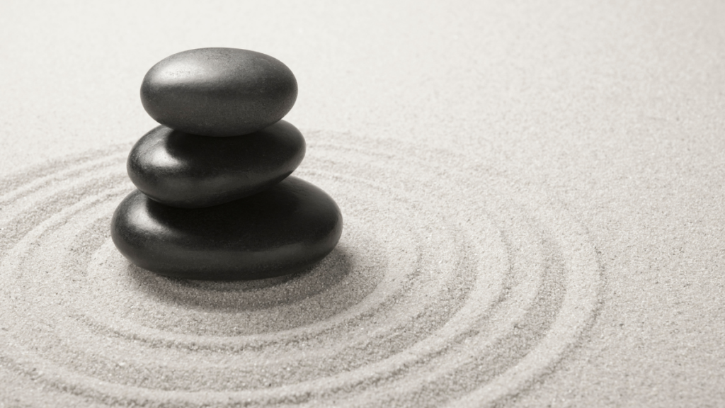 Kamienie na piasku symbolizujące harmonię i równowagę feng shui