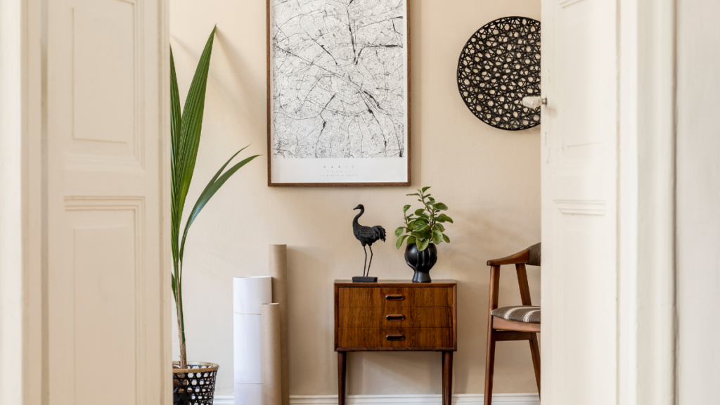 Stylowy korytarz z plakatem, rośliną i drewnianą komodą