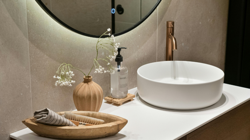 Nowoczesna łazienka z okrągłą umywalką nablatową i złotą baterią