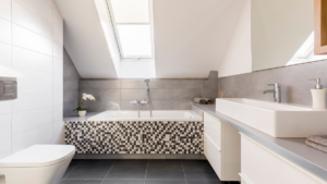 Łazienka na poddaszu z wanną pod skosem i oknem dachowym