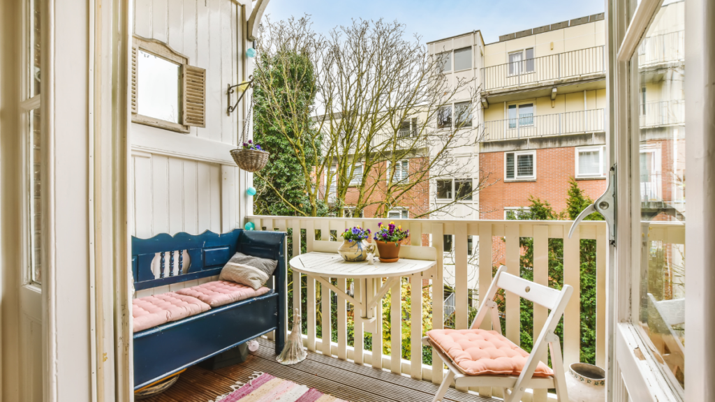 Mały balkon z miejscem do odpoczynku i drewnianą nawierzchnią