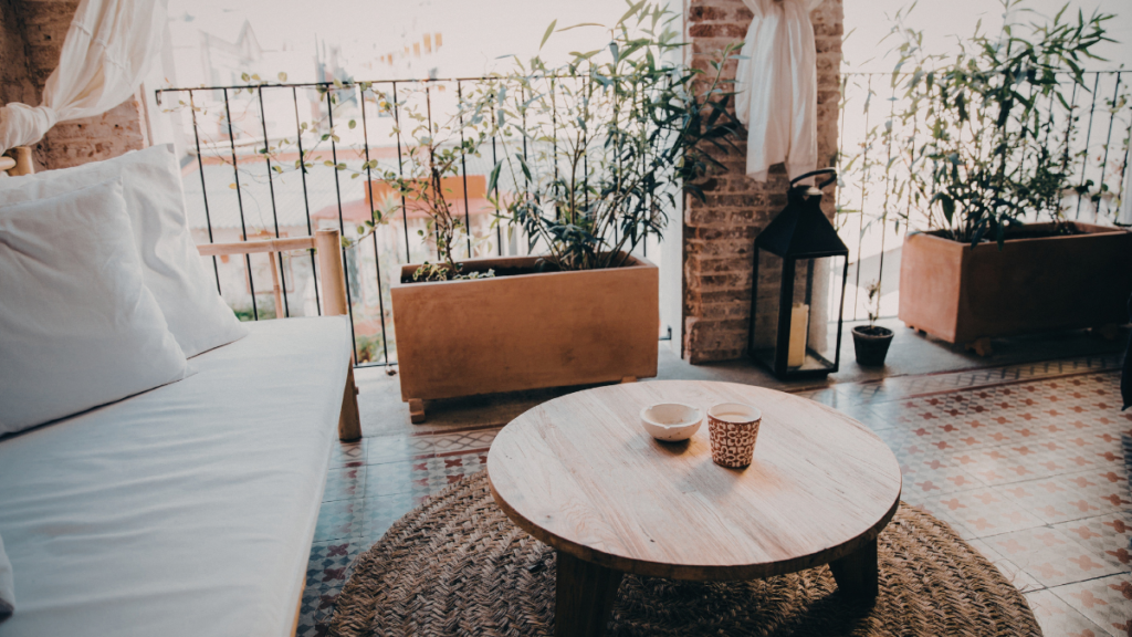 Przytulny balkon z roślinami, stolikiem i wzorzystą nawierzchnią